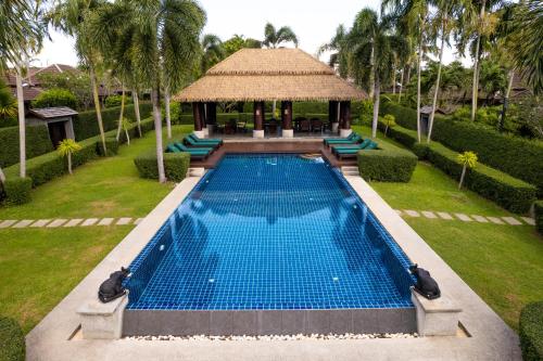 une piscine à débordement dans un complexe hôtelier avec un gazebo dans l'établissement Green Garden Villa Hotel, à Nai Harn Beach