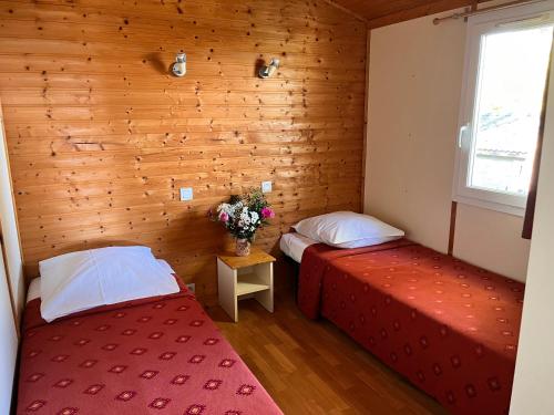 due letti in una stanza con pareti in legno di Lagrange Grand Bleu Vacances – Résidence Les Pescalunes ad Agde