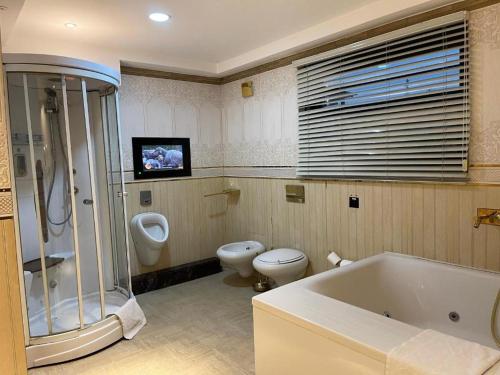 een badkamer met een bad, een toilet en een wastafel bij Hotel 5092 in Abuja