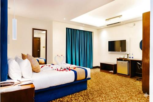 a hotel room with a bed and a flat screen tv at Marco Polo Dhaka in Dhaka