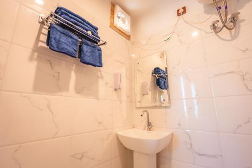 ein weißes Badezimmer mit Waschbecken und Toilette in der Unterkunft Amara Woods Villa in Rāipur