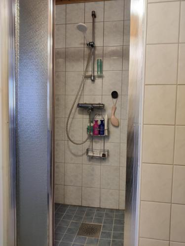 a shower with a shower head and a shower at Puskan Mummola in Pello