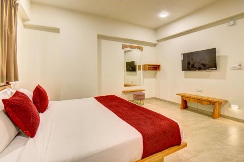 Un dormitorio con una cama grande y un televisor. en Hotel Majestic Pearl, en Nashik