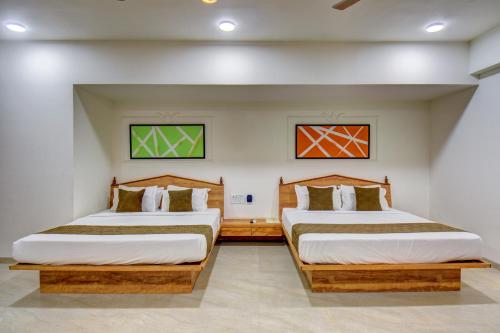 Dos camas en una habitación de hotel con dos camas. en Hotel Majestic Pearl, en Nashik