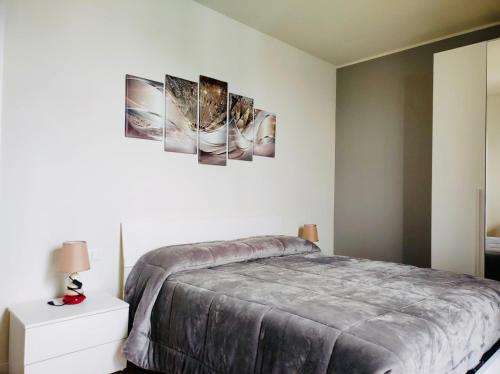 a bedroom with a bed and two paintings on the wall at Deny & Carol's house in Somma Lombardo