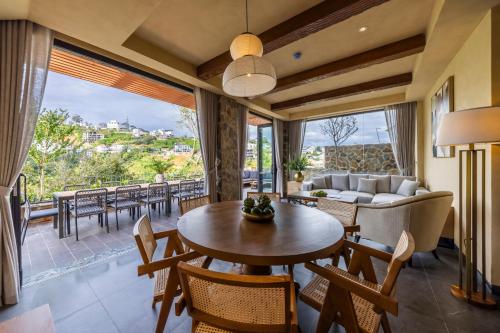 a living room with a table and chairs and a couch at Là Yên Retreat in Ấp Ða Lợi