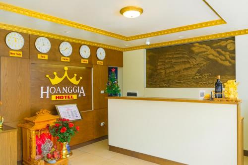 a hotel lobby with a counter and clocks on the wall at Hoàng Gia Long Biên Hotel in Hanoi