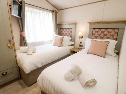 a bedroom with two beds with towels on them at Curlew Lodge in Carnforth