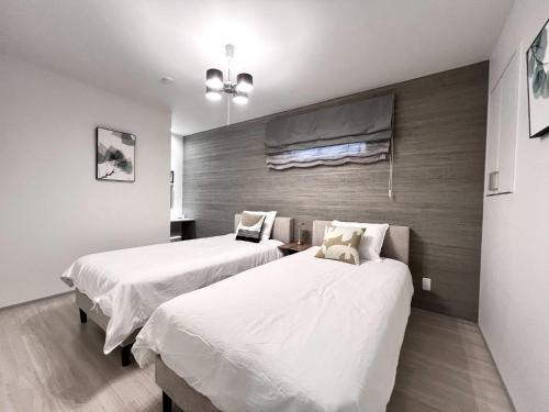 高松市にあるJasmin T 18go - Vacation STAY 31773vの白いシーツが敷かれた部屋にベッドが2つ