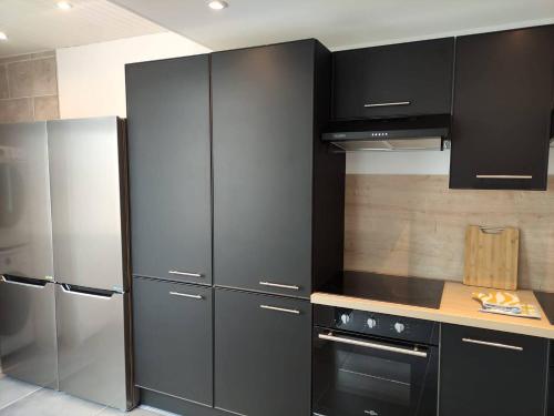 a kitchen with stainless steel appliances and black cabinets at ღ Ordemique - Coeur de ville 7 chambres, Wifi fibre in Douai