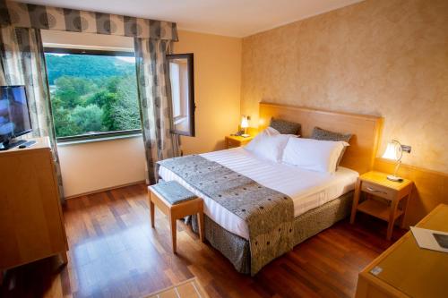 a bedroom with a large bed and a large window at Riviera Hotel in Enna