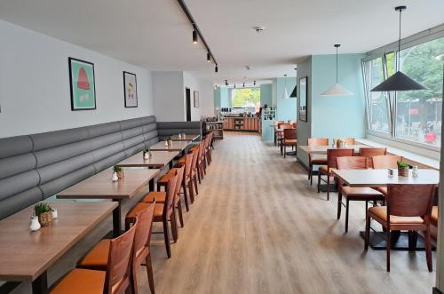 una fila de mesas y sillas en un restaurante en Garner Hotel Hamburg - Graf Moltke by IHG, en Hamburgo