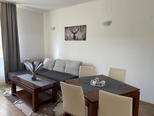 a living room with a table and a couch at Pine forest apartments in Pamporovo