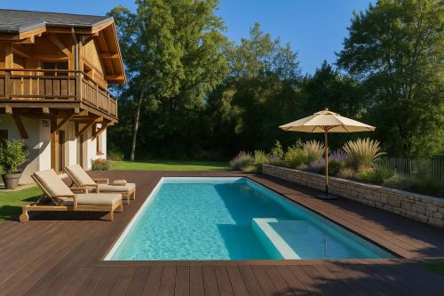 a pool with chairs and an umbrella next to a house at Chalet L'Oseraie, location touristique SPA 4 étoiles au cœur des Vosges in Le Saulcy