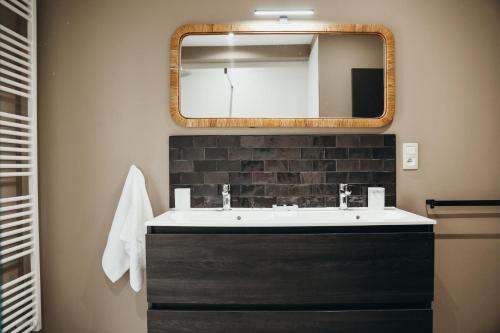 a bathroom with a sink and a mirror at Le Ruisseau - Appartement 8P in Theux