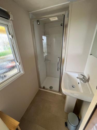 a bathroom with a shower and a sink at Mobil home 3 chambres 5 personnes Finistère in Clohars-Carnoët