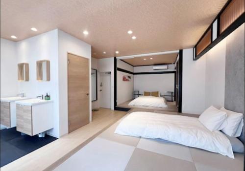 a bedroom with a large bed and a sink at Jasmin Nishikimachi 5 - Vacation STAY 13093v in Takamatsu