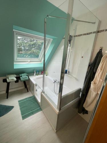 a bathroom with a tub and a glass shower at La chambre d hôtes By Georges in Scharrachbergheim Irmstett