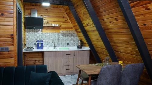 サパンジャにあるHilltop Bungalov Sapanca 3の木製の壁のキッチン(テーブル、椅子付)