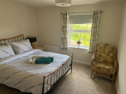 ein Schlafzimmer mit einem Bett, einem Fenster und einem Stuhl in der Unterkunft Comfortable 5 - Guest Abode - In Quiet Village in Grantham