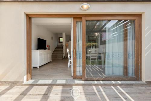 a sliding glass door of a house with a living room at Garden Delight House in Chia