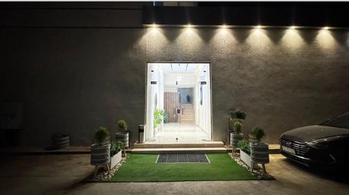 a door to a house with a green lawn at غرفة بجاكوزي مع صالة 1 من أرام ريزدنس by ARAM Residence in Aţ Ţuwayr