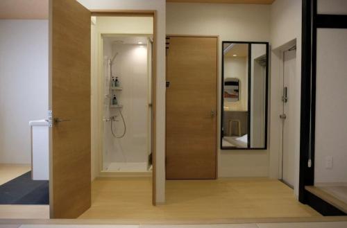 a bathroom with a wooden door and a mirror at Jasmin Nishikicho II - Vacation STAY 13055v in Takamatsu