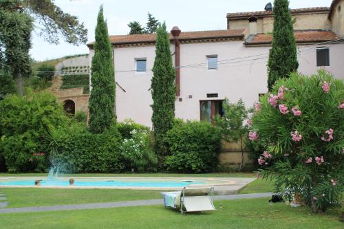 a house with a garden and a swimming pool at Palazzo Fioretti Tuscany in Terricciola