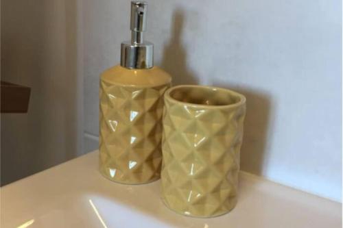 カリュイール・エ・キュイールにあるLe Refuge de la Bascule - Charmant appartement Caluire et cuireのカウンターの上に置かれた2つの花瓶とボトル、そしてカップ