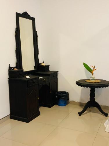a dresser with a mirror and a table with a stool at KAIMANA HOUSE - 3 Min walk to the beaches in Tangalle