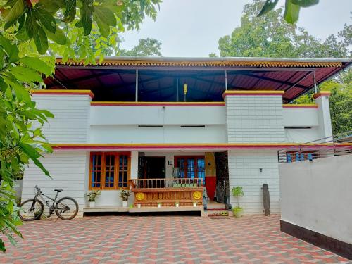 un bâtiment avec un vélo garé devant lui dans l'établissement Harmonic Hideout, à Varkala
