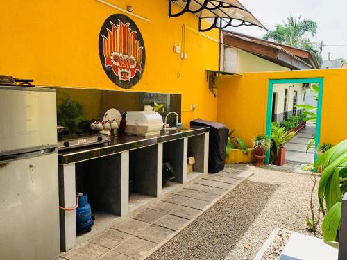 a kitchen with a counter and a yellow wall at KAIMANA HOUSE - 3 Min walk to the beaches in Tangalle