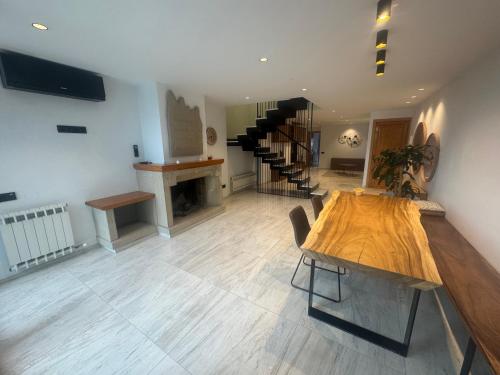 a large room with a wooden table and stairs at Casa Raval Artés in Artés