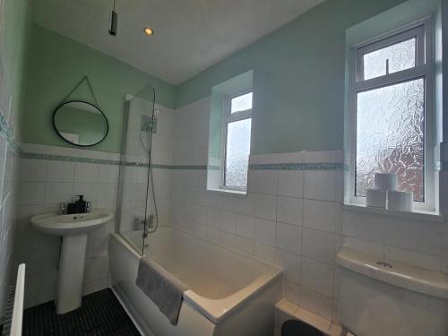 Un baño con lavabo, bañera e inodoro. en Spacious 3bedroom Apartment-Short and Long Stays-Contractors and Families, en Dunston