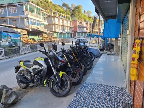 a row of motorcycles parked next to a building at TN's Basecamp Hostel in Tawang