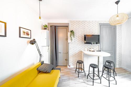 ein Wohnzimmer mit einem gelben Sofa und einem Tisch in der Unterkunft Charming 1 bedroom apartment Oullins center near metro in Oullins