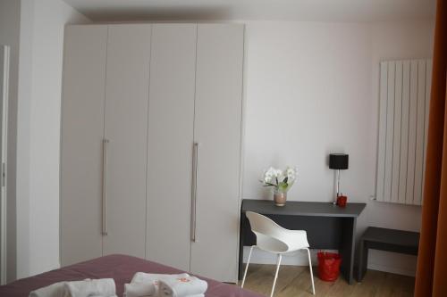 a bedroom with a bed and a desk and a white chair at Otto House short stay with style in San Daniele del Friuli