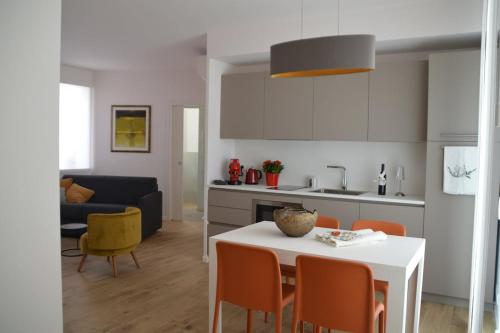 a kitchen and living room with a table and chairs at Otto House short stay with style in San Daniele del Friuli