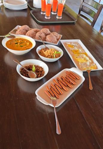 una mesa con platos de comida y tazones de comida en Villa Wansha, en Ratgama Hegoda
