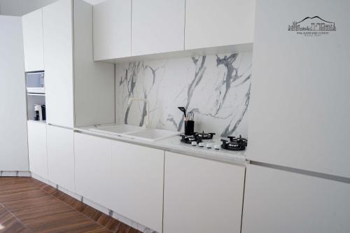 a white kitchen with white cabinets and a sink at Palazzo dei Conti in Naples