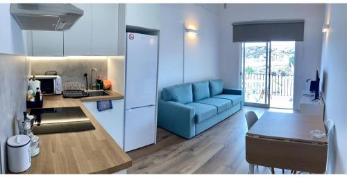 a kitchen and a living room with a blue couch at Casa Giorì Los Cristianos Castle Harbour in Los Cristianos