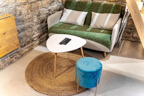 un soggiorno con divano, tavolo e sgabello di Le petit Victor Hugo - studio Bellecour a Lione