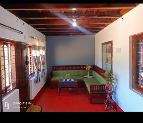 a living room with a green couch and a table at Divine home stays in Madikeri