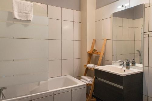 a bathroom with a bath tub and a sink at Logis Hôtel Saint Cyr in La Ferté-Saint-Cyr