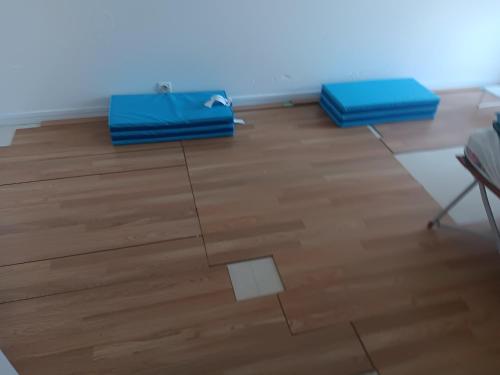 two blue bags sitting on top of a wooden floor at Olembe Garden in Avon