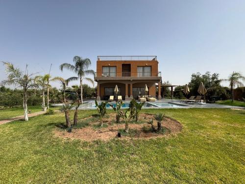 une maison avec une piscine et une cour avec des palmiers dans l'établissement Luxury family villa with private pool, à Douar bel Rhanodour