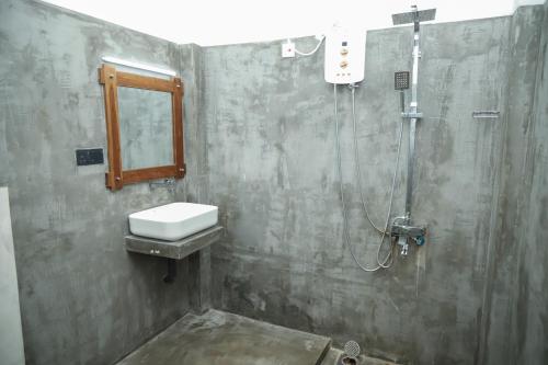 ein Badezimmer mit Waschbecken und Dusche in der Unterkunft Ibbankatuwa Lake Resort in Dambulla