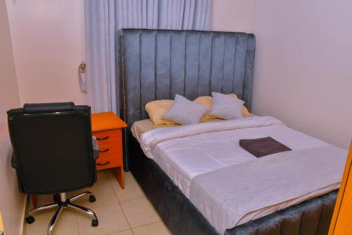 a bedroom with a bed and a desk and a chair at Genesis Grove BnB Syokimau in Syokimau