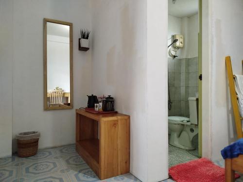 a bathroom with a mirror and a sink and a toilet at Hamada's Guesthouse in Baler