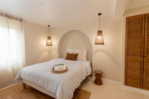 ein Schlafzimmer mit einem weißen Bett und einem Korb darauf in der Unterkunft Suite Baniléa & Spa in Brest